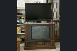 Large old tv with old flat screen on top